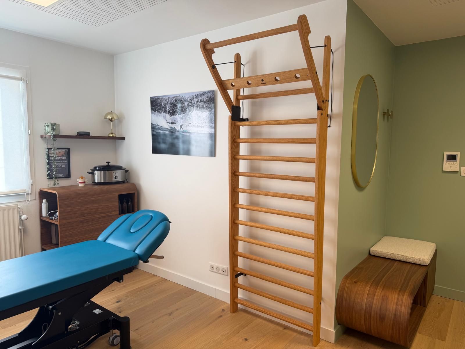 Salle de soin avec table de massage et espalier